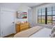 Well lit bedroom with a TV, wooden dresser, and a large window overlooking the outdoors at 723 S Blvd Of The Presidents, Sarasota, FL 34236