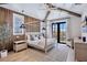 Bright bedroom with wood accent wall, exposed beams, neutral decor, and access to a private balcony at 723 S Blvd Of The Presidents, Sarasota, FL 34236