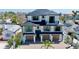 Elegant three-story home with a black roof, a three-car garage and brick paver driveway at 723 S Blvd Of The Presidents, Sarasota, FL 34236