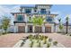 Stunning three-story home with a brick driveway, three car garage, and lush tropical landscaping at 723 S Blvd Of The Presidents, Sarasota, FL 34236