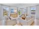 Bright living room with large windows, modern furniture, and a stylish ceiling fan at 723 S Blvd Of The Presidents, Sarasota, FL 34236