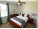 Cozy bedroom featuring a ceiling fan, wooden furniture, and a sunlit window with dark green drapes at 7360 Talon Bay Dr, North Port, FL 34287