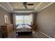 The main bedroom is well-lit, featuring a decorative tray ceiling, large windows, and neutral-toned walls at 7360 Talon Bay Dr, North Port, FL 34287