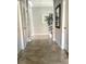 Elegant hallway with neutral tile flooring and a decorative mirror and plant at 7360 Talon Bay Dr, North Port, FL 34287