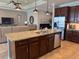 Open-concept kitchen with granite island, stainless steel appliances, and dark wood cabinetry flowing into the living room at 7360 Talon Bay Dr, North Port, FL 34287