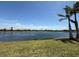 Scenic lake view showcases lush greenery and clear blue skies, enhancing the serene outdoor living at 7360 Talon Bay Dr, North Port, FL 34287