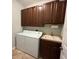 Well-equipped laundry room with washer, dryer, sink, and ample cabinet space at 7360 Talon Bay Dr, North Port, FL 34287
