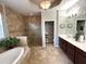Luxurious main bathroom featuring a soaking tub, patterned walls and a double vanity at 7360 Talon Bay Dr, North Port, FL 34287