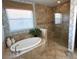 Elegant main bathroom with a separate shower and tub, plus a bright window at 7360 Talon Bay Dr, North Port, FL 34287