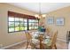 Cozy dining area with a round glass table, four chairs, and a large window with peaceful outdoor views at 7639 Fairway Woods Dr # 605, Sarasota, FL 34238