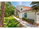 Exterior view of the condo with walkway, mature trees, and landscaping showcasing its peaceful setting at 7639 Fairway Woods Dr # 605, Sarasota, FL 34238