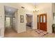 Spacious foyer features a decorative door, chandelier, and views into the living spaces at 7639 Fairway Woods Dr # 605, Sarasota, FL 34238