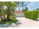 A well-maintained two-car garage with palm trees and tropical foliage in a landscaped yard at 7639 Fairway Woods Dr # 605, Sarasota, FL 34238