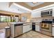 A well-lit kitchen boasts stainless steel appliances, ample counter space, and tile flooring at 7639 Fairway Woods Dr # 605, Sarasota, FL 34238
