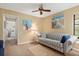 Cozy living room featuring striped sofa, tropical artwork, and comfortable seating arrangement at 7639 Fairway Woods Dr # 605, Sarasota, FL 34238