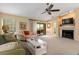 Comfortable living room featuring a fireplace, neutral carpet, ceiling fan and access to an outdoor patio at 7639 Fairway Woods Dr # 605, Sarasota, FL 34238