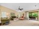 Spacious living room with neutral carpet, ceiling fan, and large glass door to the balcony, maximizing natural light at 7639 Fairway Woods Dr # 605, Sarasota, FL 34238