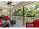 A screened patio with ceiling fan and furniture provides serene outdoor living and views of lush landscaping at 7639 Fairway Woods Dr # 605, Sarasota, FL 34238