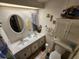 Bathroom featuring double sinks, white cabinets and an over-the-toilet cabinet at 808 53Rd E Ave # 229, Bradenton, FL 34203