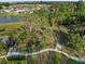 Scenic aerial view of a park area with green space, walking path, mature trees, and community pond at 9725 Last Light Gln, Parrish, FL 34219