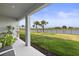 A covered patio overlooks the spacious backyard with a view of the water and palm trees at 9725 Last Light Gln, Parrish, FL 34219