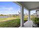 Covered patio overlooking the grassy backyard and serene water view at 9725 Last Light Gln, Parrish, FL 34219