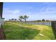 Spacious backyard with lush green grass, a fenced yard, and serene water views at 9725 Last Light Gln, Parrish, FL 34219