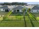 View of the backyard with a black metal fence and two palm trees in a well maintained grassy lawn at 9725 Last Light Gln, Parrish, FL 34219