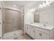 Well-lit bathroom featuring a double vanity with stone countertops and a glass-enclosed walk-in shower at 9725 Last Light Gln, Parrish, FL 34219