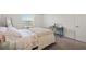 Cozy bedroom with plush carpet, a window, and neutral decor with a comfortable bed and a blue desk at 9725 Last Light Gln, Parrish, FL 34219