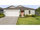 Charming single-Gathering home featuring an attached two car garage, manicured lawn, and bright coral front door at 9725 Last Light Gln, Parrish, FL 34219