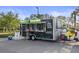 Modern black food truck with signage and ordering window parked on a paved lot near landscaping at 9725 Last Light Gln, Parrish, FL 34219