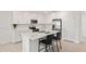 Bright kitchen features white cabinets, stainless steel appliances, and an island with bar stool seating at 9725 Last Light Gln, Parrish, FL 34219