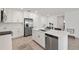 Bright kitchen boasts stainless steel appliances, white cabinetry, and a center island with seating at 9725 Last Light Gln, Parrish, FL 34219