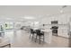 Open-concept kitchen showcases stainless appliances, white cabinets, and an island with bar stools; open to living areas at 9725 Last Light Gln, Parrish, FL 34219