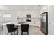 Stylish kitchen features white cabinets, stainless steel appliances, and a spacious island with bar stool seating at 9725 Last Light Gln, Parrish, FL 34219