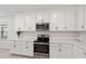 Modern kitchen featuring white cabinets, stainless steel appliances, and sleek countertops at 9725 Last Light Gln, Parrish, FL 34219