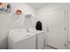 Laundry room with a white washer and dryer, overhead shelving, and a door at 9725 Last Light Gln, Parrish, FL 34219