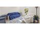 Bright living room with a blue sofa, area rug, white armchair, and a plant by the window at 9725 Last Light Gln, Parrish, FL 34219
