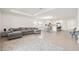 Open concept living room with gray sofa, tile floors, and a view of the modern kitchen and dining area at 9725 Last Light Gln, Parrish, FL 34219