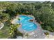 Aerial view of community pool, with lounge chairs and palm trees around the perimeter at 9725 Last Light Gln, Parrish, FL 34219