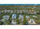 Gorgeous aerial view of waterfront home with private dock and lush landscaping at 5024 Commonwealth Dr, Sarasota, FL 34242