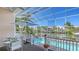 View of a screened-in pool, deck with table for entertaining, and a scenic canal at 5024 Commonwealth Dr, Sarasota, FL 34242