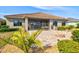 The house's backyard has a fire pit, patio, outdoor kitchen, and tropical shrubbery at 10816 O Meara Way, Englewood, FL 34223
