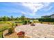 This backyard features a paver patio area and tranquil pond views with manicured landscaping at 10816 O Meara Way, Englewood, FL 34223