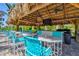 Charming tiki bar with seating under a thatched roof, ideal for poolside refreshments at 10816 O Meara Way, Englewood, FL 34223