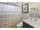 Cozy bathroom features a shower with neutral tile, a toilet, and a stylish vanity at 10816 O Meara Way, Englewood, FL 34223