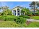 Exterior of a well-maintained clubhouse featuring manicured landscaping and elegant architectural details at 10816 O Meara Way, Englewood, FL 34223