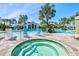 Relaxing hot tub next to a swimming pool, featuring lush tropical landscaping and comfortable lounge seating at 10816 O Meara Way, Englewood, FL 34223