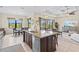 Bright kitchen features a large island with granite countertops, stainless steel appliances and pendant lighting at 10816 O Meara Way, Englewood, FL 34223